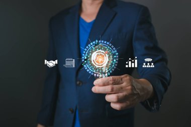 Bir profesyonel, takım çalışması, planlama ve büyüme sembolleriyle çevrili, hedef belirleme, iş stratejisi ve işbirliği ve odaklanma yoluyla başarıya ulaşmanın vurgulandığı parlak bir hedef simgesine sahiptir..