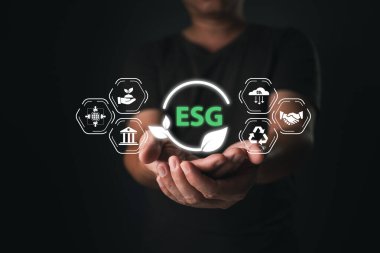 A person holds an icon symbol energy conservation, climate change awareness, eco-friendly investment, representing ESG principles, green business innovation, and sustainable development.