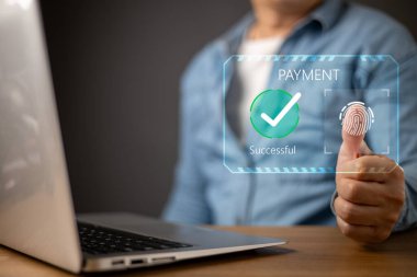 Bir kişi, bir dizüstü bilgisayardaki online ödeme için biyometrik parmak izi taraması kullanır. Fütürist dijital arayüz, yeşil işaretli ve sembol güvenli işlemleri ile başarılı bir ödeme yapar.