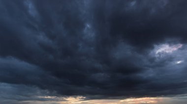 Girdap gibi bulutlarla dolu karanlık gökyüzü yaklaşan bir fırtınayı işaret ediyor. Havadaki dramatik değişimleri ve doğanın muazzam gücünü vurguluyor..