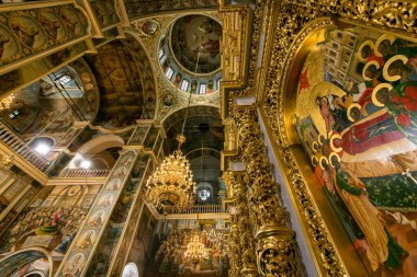 Gorgeously decorated golden altar and frescoes on the walls in the interior of the Holy Dormition Cathedral in Pechersk Lavra in Kyiv, Ukraine January 7, 2023. High quality photo