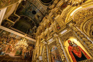 Gorgeously decorated golden altar and frescoes on the walls in the interior of the Holy Dormition Cathedral in Pechersk Lavra in Kyiv, Ukraine January 7, 2023. High quality photo