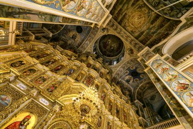Gorgeously decorated golden altar and frescoes on the walls in the interior of the Holy Dormition Cathedral in Pechersk Lavra in Kyiv, Ukraine January 7, 2023. High quality photo