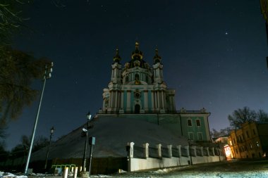 The starry sky above the St. Andrew Church at the Andriyivskyy Uzviz Descent Street in Kyiv, Ukraine. December 2022. High quality photo