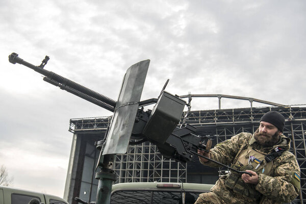 Член мобильной группы ПВО проверяет пулемет ДШК на пикапе в городе Гостомель, Украина, 1 апреля 2023 года. Высокое качество фото