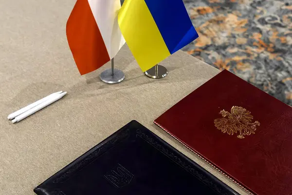National flags of Ukraine and Poland at the table for signing a bilateral agreement, document, contract. High quality photo