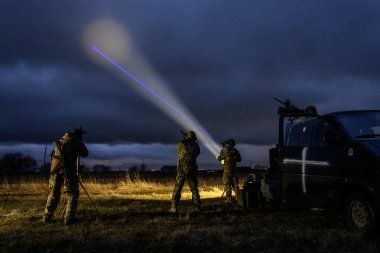 Ukrayna Silahlı Kuvvetleri 'nin İHA avcıları olarak bilinen hava savunma birimi 24 Mart 2024' te Ukrayna 'nın Kyiv bölgesinde gece vakti güçlü bir projektörle gökyüzünü aydınlatır.. 