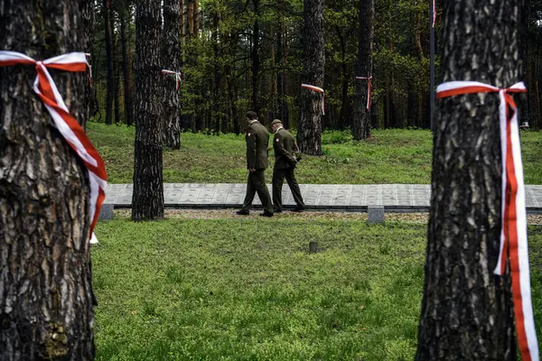 stock image Polish servicemen stand near Memorial wall with the names of Poles, victims of Stalinist repressions at Polish military cemetery Polish graves Bykivnia, near Kyiv, Ukraine 2024, April 13