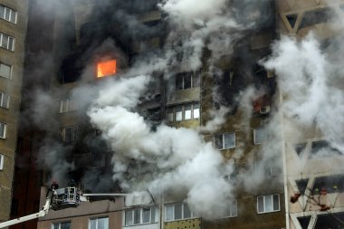 İtfaiyeciler, 7 Şubat 2024 'te Ukrayna' nın başkenti Kyiv 'de meydana gelen büyük bir Rus füze saldırısında hasar gören yüksek katlı bir binada çalışıyorlar. Yüksek kalite fotoğraf