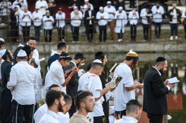 Orthodox Jewish pilgrims pray on the bank of lake near the tomb of Rabbi Nachman while celebrating Rosh Hashanah, Jewish New Year, amid Russia continues the war in Ukraine. Uman, Ukraine 16-09-2023 clipart