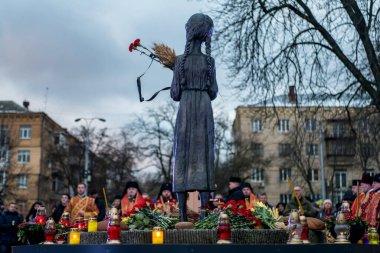 İnsanlar, Ukrayna 'nın başkenti Kyiv' de, 23 Kasım 2024 'te, 1932-33 yıllarındaki kıtlığın 92. yıldönümü münasebetiyle düzenlenen bir anma töreninde, Holodomor kurbanlarının anıtlarını ziyaret ediyor.