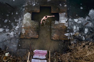 Havadan bakıldığında, Ukraynalı Ortodoks inananların Ukrayna 'nın başkenti Kyiv' de devam eden Rus işgali sırasında 06 Ocak 2025 'te düzenlenen Epifani kutlamaları sırasında soğuk suda yıkandıklarını gösteriliyor. Yüksek kalite fotoğraf