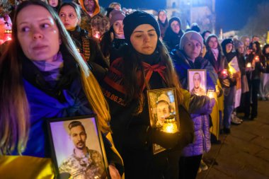 Rusya 'nın 24 Şubat 2025' te Ukrayna 'yı işgalinin üçüncü yıldönümü olan Kyiv' deki Bağımsızlık Meydanı 'nda şehit düşen Ukraynalı ve yabancı askerler için yapılan derme çatma törende insanlar anma töreni düzenliyor.