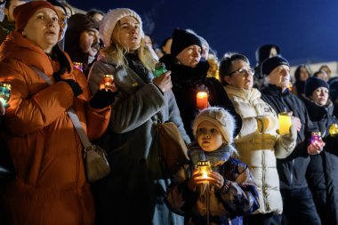 Rusya 'nın 24 Şubat 2025' te Ukrayna 'yı işgalinin üçüncü yıldönümü olan Kyiv' deki Bağımsızlık Meydanı 'nda şehit düşen Ukraynalı ve yabancı askerler için yapılan derme çatma törende insanlar anma töreni düzenliyor.
