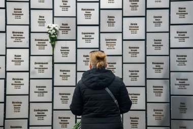 İnsanlar, Rus işgali kurbanlarının anısına 30 Mart 2025 'te, Bucha, Ukrayna' da Rus kuvvetleri tarafından öldürülen sivillerin toplu mezarı yerine çiçek getiriyor. Yüksek kalite fotoğraf