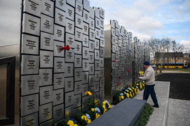 İnsanlar, Rus işgali kurbanlarının anısına 30 Mart 2025 'te, Bucha, Ukrayna' da Rus kuvvetleri tarafından öldürülen sivillerin toplu mezarı yerine çiçek getiriyor. Yüksek kalite fotoğraf