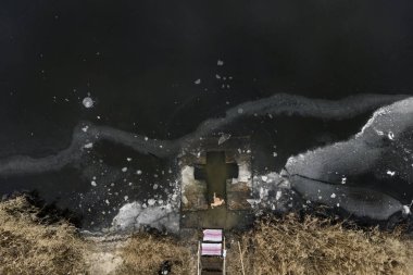 Havadan bakıldığında, Ukraynalı Ortodoks inananların Ukrayna 'nın başkenti Kyiv' de devam eden Rus işgali sırasında 06 Ocak 2025 'te düzenlenen Epifani kutlamaları sırasında soğuk suda yıkandıklarını gösteriliyor. Yüksek kalite fotoğraf