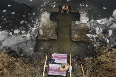 Havadan bakıldığında, Ukraynalı Ortodoks inananların Ukrayna 'nın başkenti Kyiv' de sürmekte olan Rus işgali sırasında 06 Ocak 2025 'te düzenlenen Epifani kutlamaları sırasında soğuk suda yıkandıkları görülüyor. Yüksek kalite fotoğraf