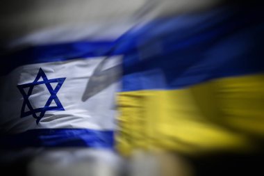 Ukrayna ve İsrail 'in ulusal bayrakları parlak güneş ışığı altındaki bir idari binanın yakınındaki bayrak direkleri üzerinde sallanarak diplomatik bağları, siyasi işbirliğini ve karşılıklı desteği simgeliyor. Yüksek kalite fotoğraf