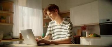 Genç bir profesyonel, yaratıcılığa ilham veren, bitkilerle kaplı, parlak bir mutfak atölyesinde çalışıyor.