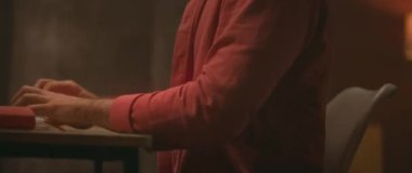 Rahat bir ortamda, bir insan bilgisayarında masasında odaklanmış ve üretken bir işle meşgul olur.