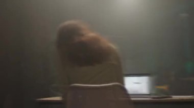 Dizüstü bilgisayarının başında, etrafındaki sıcak ve yumuşak ışıkla harika bir şekilde aydınlatılmış bir insan.