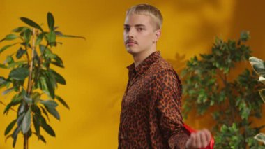 Gay gökkuşağı bayrağında bıyıklı, kendine güvenen bir adamın fotoğraf stüdyosu kameraya bakıyor.