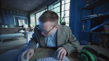 Yüzü kapayan duygusal adam gözlüğü kaldırıyor. Klavyede bilgisayar kullanıyor. Ekranda yazı yazıyor. İnek. Aktif iş. Ofis ya da daire