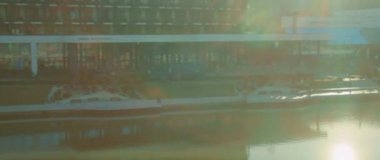 FPV insansız hava aracı modern otel ve spa alanıyla gölün üstünden ateş ediyor. Güneş ışığı günü. Hava manzaralı seyahat turizmi. - Su. Dinlenme zamanı.