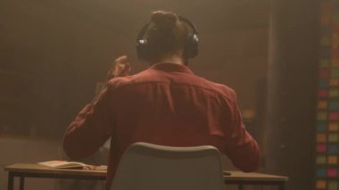 360 derecelik hızlandırılmış oturma odası. Sakallı, kulaklık takan ve müzikten hoşlanan beyaz bir genç. Masada piyano çalarken taklit eden ve ritme göre hareket eden adam. Parallaks etkisi. Sinematik. Dinlenme zamanı.