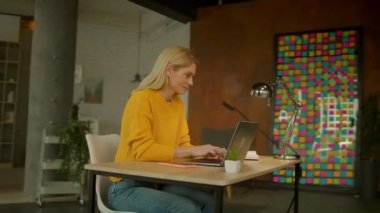 Dizüstü bilgisayarda yazı yazan güzel bir iş kadını. Ofisteki not defterine not al. Yoğun bir iş günü. Kamera hareket ediyor. 360 derece