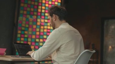 Çekici bir adam bilgisayarını kapattı. Ofiste gülümseyip düşünürken mutlu oluyor. Çok ciddiyim. Kamera hareket ediyor. 360 Derece