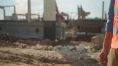 Sarı yelekli adamın elleri ve beyaz gömlekli adamın inşaat alanının bulanık arka planında el sıkışması. Anlaşma kavramı. İş için. Jeodezi. Açık havada.