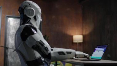 360 derecelik hareketli android görüntüsü masada oturuyor ve dizüstü bilgisayarın klavyesini daktilo ediyor. Beyaz robot hareket ediyor ve parmaklarını oynatıyor. Yapay zeka. Makine öğrenimi. Parallaks etkisi