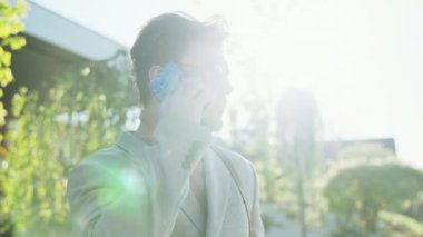 Gün ışığında gözlüklü bir adam şehirde cep telefonuyla konuşuyor. Kendine güvenen genç iş adamları dışarıda sohbet ederler.