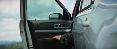 Şık bir genç adam şapkasıyla arabadan iniyor ve dağların ormanlarına bakıyor. Mutlu ol.