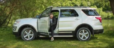 Çekici bir adam arabadan iniyor ve dağ ormanlarında bagajı açıp etrafa bakıyor. Mutlu ol. Dinlenme zamanı.