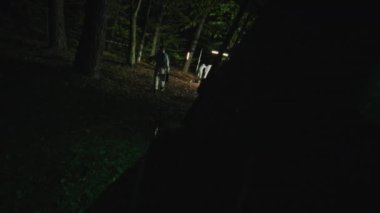 Dedektifin kullandığı eller gece vakti kürek araması yapar. Orman, güvenlik, ekipman, projektör, sis, suçlu. POV çekimi