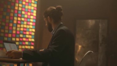 Ciddi bir iş adamının portresi masaya oturup kağıtlarla çalışmak. Gece ofisindeki bilgisayarı kullan. İşine odaklan. Akşam ışığı