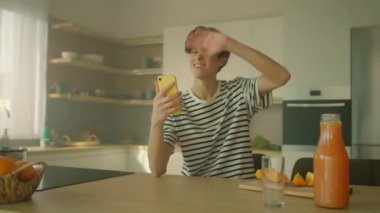 360 derece zaman ayarlı. Neşeli, genç, beyaz bir adam akıllı telefondan video görüşmesi yapıyor. Elinde cep telefonu olan ve konuşan bir adam. Erkek öğrenci sohbetten zevk alıyor. İz sürme