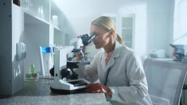 Laboratuvarda mikroskop altında araştıran bir bilim kadını. İlaçlar, biyoteknoloji araştırmaları. Farmakoloji