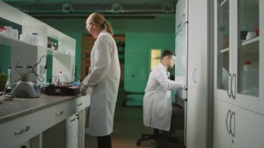 Laboratuvarda gözlüklü iki bilim adamı birlikte çalışıyor. Tıp, biyoteknoloji, kimya. Eczacılık. Deney