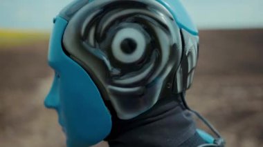 Yakın plan mavi droid cyborg aktif halde çiftlik alanındaki kameraya bakıyor. Gelecekçi robotik çiftçi. Akıllı tarım yenilikleri. Robot endüstrisi. Robocrop. Mühendislik.