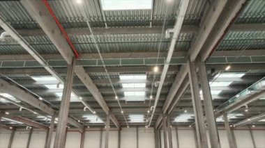Geniş ve geniş bir deponun iç kısımlarında yatay çekim. Lojistik merkezindeki boş depo. Beton zemini olan büyük bir dağıtım merkezi. Mal depolama konsepti. Endüstriyel Kapalı