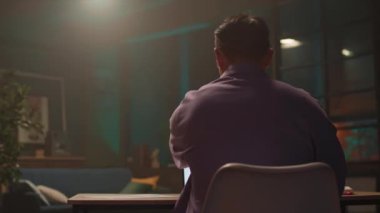 Gözlüklü çekici Asyalı iş adamı dizüstü bilgisayar kullanır ve notlar alır. Gece mesaisi. Ekranda ciddi bir görünüm. 360 derece. Etrafta dolanıyorum.