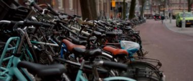 Canlı ve canlı bir sahne Amsterdam 'ın güzel caddeleri boyunca parkedilmiş sayısız bisikleti gösteriyor.