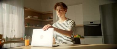 Beyaz erkek öğrencinin bilgisayarını kapatırken ve modern, güzel bir mutfakta işini bitirirken 360 derece izleme görüntüsü. Dijital konsept. Parallaks etkisi. Kamera hareket ediyor