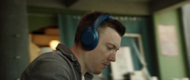 Bir birey, modern ofis ortamında bulanık bir monitörün arkasında, işine derinden bağlıdır.