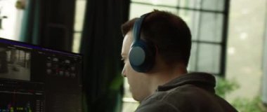 İşlerine odaklanmış, kısmen bir bilgisayar monitörü tarafından gizlenmiş, yoğun bir konsantrasyon gösteren bir profesyonel.