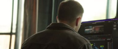 Modern bir ofiste bilgisayarın arkasında özenle çalışan odaklanmış bir birey yaratıcılığı ve üretkenliği teşvik ediyor.